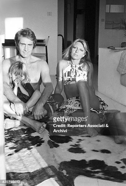 Italian actor, comedian and TV host Walter Chiari on vacation in his Sardinian villa sitting on the floor next to his wife, Italian actress and...