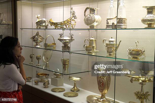 Woman viewing silver-plated display case at the Rhode Island School of Design Museum of Art.