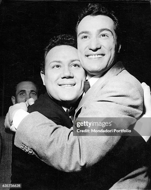 The singers Claudio Villa and Nunzio Gallo hugging each other after they won the 7th Sanremo Music Festival with the song Corde della mia chitarra....