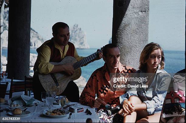 The Florentine fashion designer, Emilio Pucci, lunching in Capri with his wife Christina, Italy, 1959. Pucci once had the guitarist who is serenading...