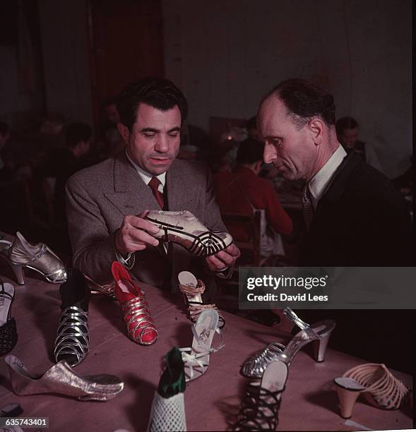 Italian shoe designer Salvatore Ferragamo discussing a selection of his shoes.