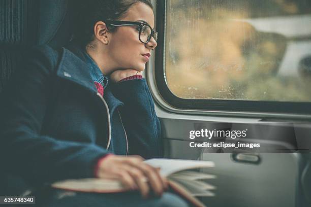 girl riding a commuter rail train - lightrail commuter stock pictures, royalty-free photos & images