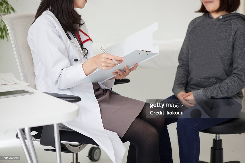The female doctor explains to the patient.