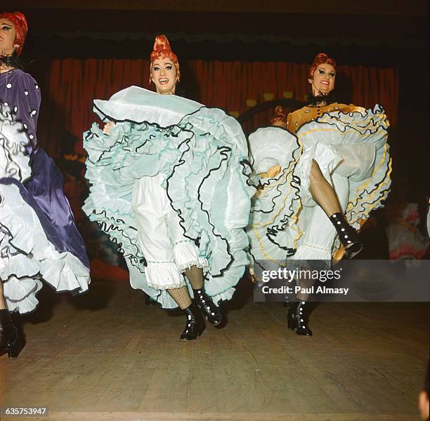 Dancers perform the trademark can-can in clouds of petticoats at the Montmartre district's famous Moulin Rouge. They wear traditional costumes in...