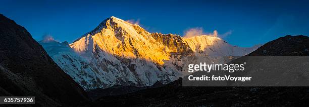 cho oyu 8201m himalaya mountain peak illuminated by golden light - himalayas sunrise stock pictures, royalty-free photos & images