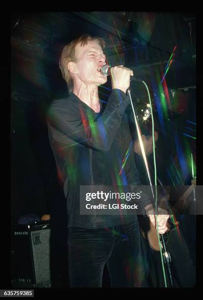 Jim Carroll on stage performing. He is shown waist-up, singing. Photograph, 1980.