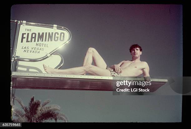 Las Vegas: Photo shows Rock Hudson lying sideways on the diving board of the pool at the Flamingo Hotel in Las Vegas. Ca. 1940s-1950s.