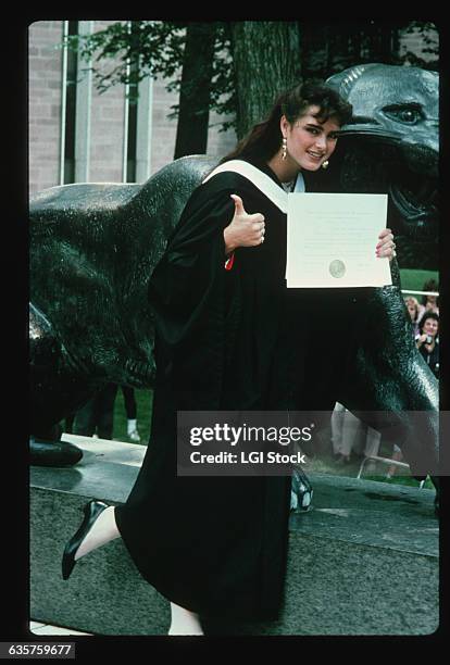 Brooke Shields holds her diploma from Princeton University on her graduation day.