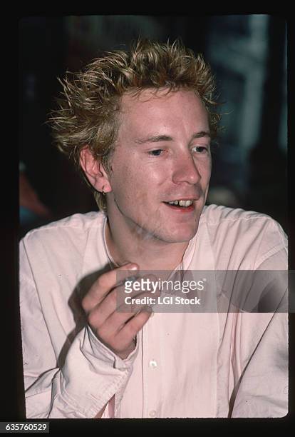Close-up of British musician John Lydon of the band Public Image Ltd. He is talking, smoking a cigarette and wears a pink suit. Lydon is also known...