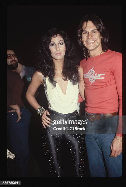 Cher and K.C., from K.C. And the Sunshine Band pose together at a party. Cher wears rhinestone studded spandex.