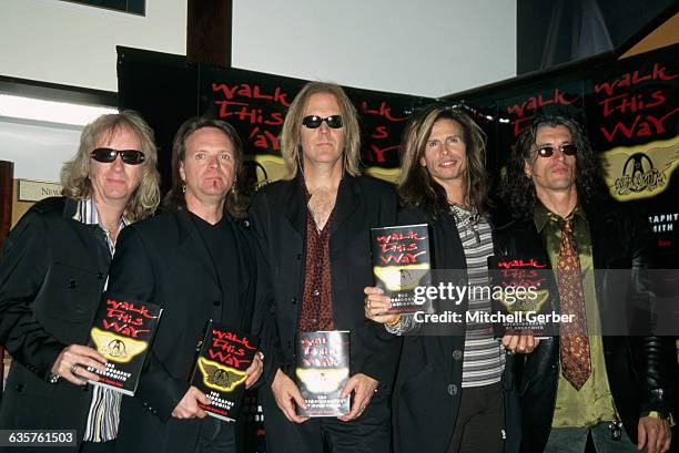 Members of Aerosmith pose during a book signing at Barnes & Noble on Fifth Avenue. They are shown holding copies of the band's autobiography, Walk...