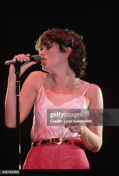 Linda R Singer Linda Ronstadt is shown on stage performing. She sings into a ...