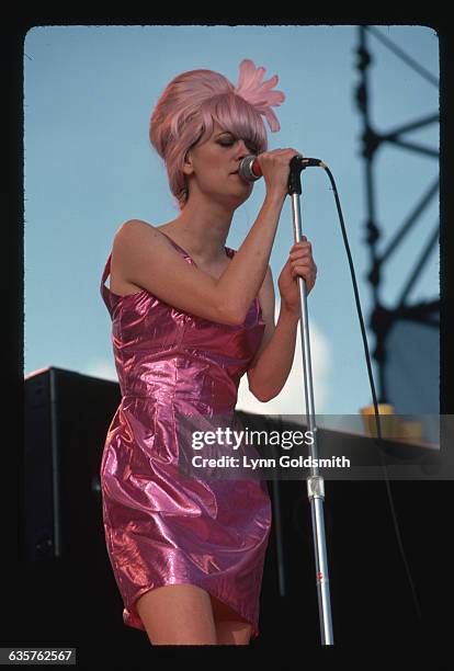 Cindy Wilson, singer with the B-52s, is shown singing on stage.