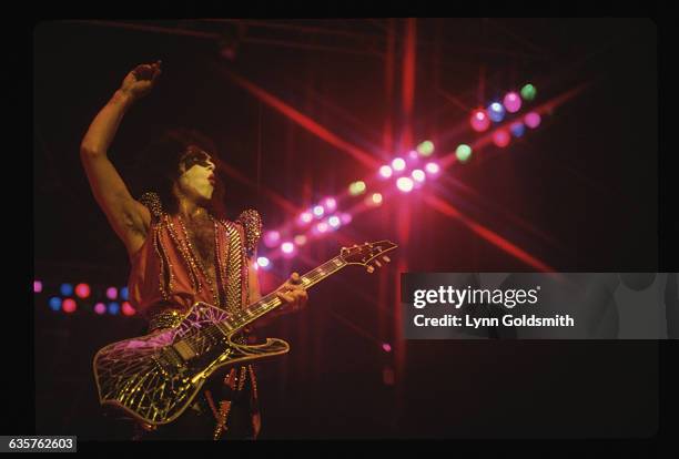 Member of rock group, Kiss, playing the bass guitar. Undated photograph.