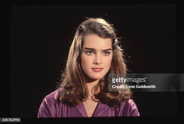 Head shot of actress and model Brooke Shields in a purple blouse.