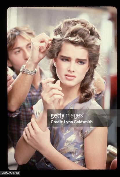 Brooke Shields has her hair done by a hairdresser before the filming of a commercial.