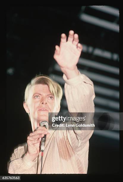 David Bowie, points the heavens, as he performs on stage.