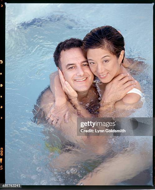 Fashion designer Vera Wang and her husband Arthur Becker embrace in a swimming pool.