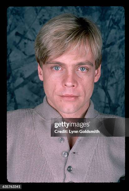 Actor Mark Hamill is shown in this close-up studio portrait. His hair is blonde and he wears a tan round-collared shirt with buttons. Undated.