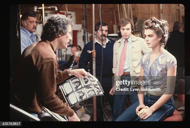 Members of a film crew talk with actress Brooke Shields on a set during the filming of a television commercial for Wella Balsam shampoo.