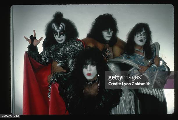 Studio portrait of the theatrical, American rock & roll band Kiss dressed in costume and wearing their trademark make-up. In front is guitarist and...