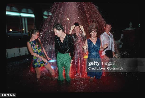 The members of the new wave band the B-52s stand in a fountain.