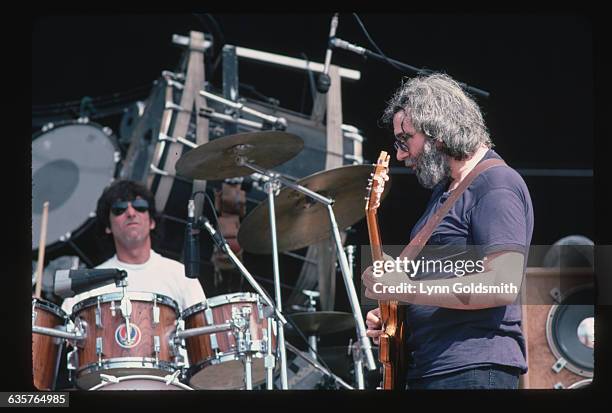 Grateful Dead frontman Jerry Garcia plays guitar with Mickey Hart on the drums.