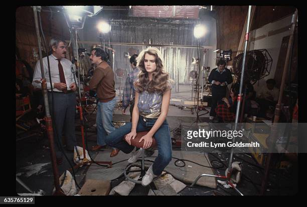 Brooke Shields sits on a set during the filming of a television commercial for Wella Balsam shampoo.