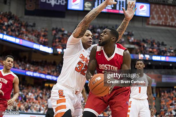 Justin Alston of the Boston University Terriers drives to the basket as he is guarded by DaJuan Coleman of the Syracuse Orange during the first half...