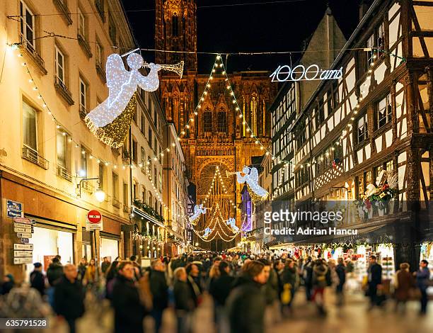 christmas in france tourists admiring christmas decorations on the iconic rue merciere strasbourg - strasbourg stock pictures, royalty-free photos & images