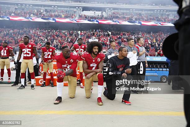 Eli Harold, Colin Kaepernick and Eric Reid of the San Francisco 49ers kneel on the sideline, during the anthem, prior to the game against the New...