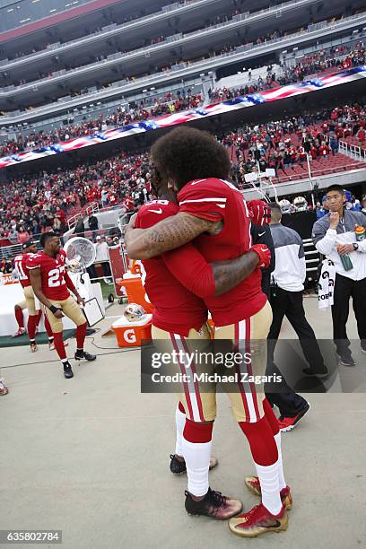 Eli Harold and Colin Kaepernick of the San Francisco 49ers embrace on the sideline, following the anthem, prior to the game against the New York Jets...