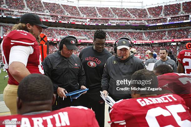 Offensive Line Coach Pat Flaherty and Head Coach Chip Kelly of the San Francisco 49ers talk with the offensive line on the sideline during the game...