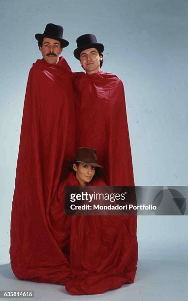 The comic trio formed by Massimo Lopez, Anna Marchesini and Tullio Solenghi posing wrapped in a huge red sheet, with hats. Italy, 1990