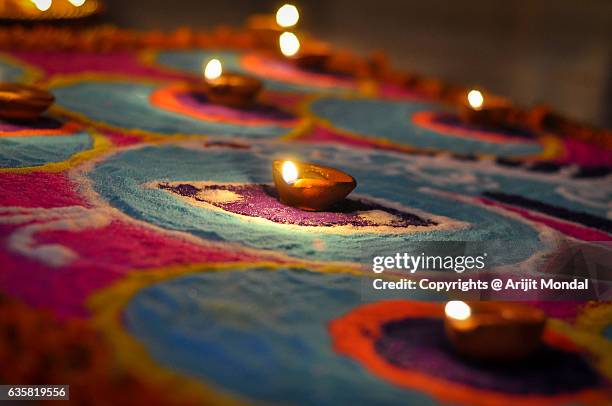 hand made oil lamps decorated with rangoli in the festive night of hindu festival diwali or deepavali - rangoli stock-fotos und bilder