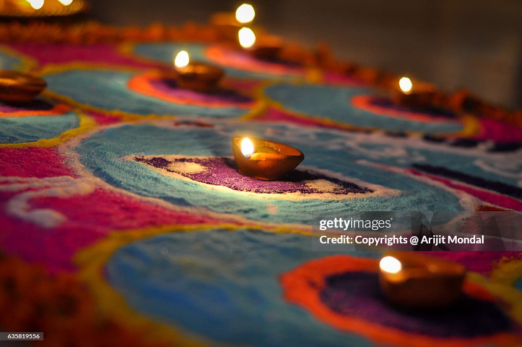 Hand made oil lamps decorated with Rangoli in the festive night of Hindu festival Diwali or Deepavali