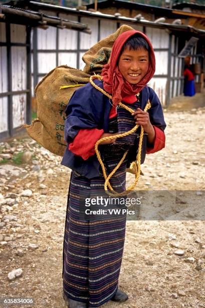 Bhutanese boy carrying a sack with a rope sling, Jakar, Bhutan. Digitally Manipulated Image. Stylised by sharpening and enhancing color.