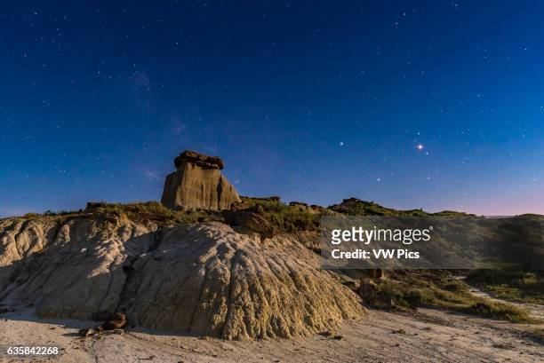Mars shining brightly near its May 22, 2016 opposition in the head of Scorpius over the badlands of Dinosaur Provincial Park, Alberta. Saturn is to...