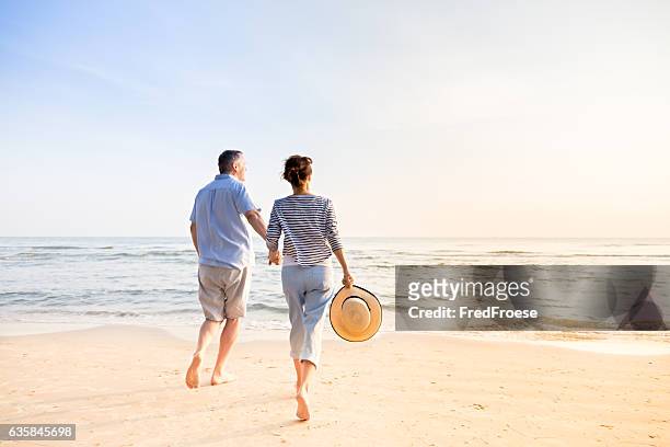 paar am strand  - senioren spazieren sommer stock-fotos und bilder