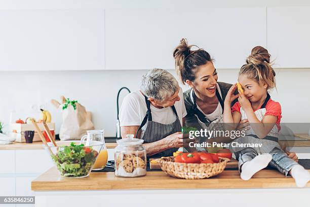 drei generationen frauen in der küche - young man groceries kitchen stock-fotos und bilder