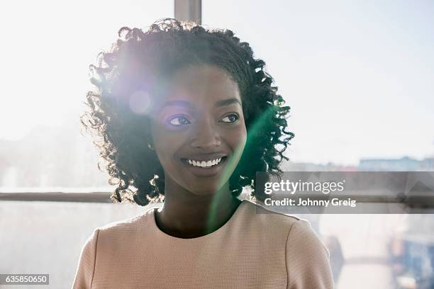 happy young businesswoman with curly black hair smiling - candid beautiful young woman face stock pictures, royalty-free photos & images