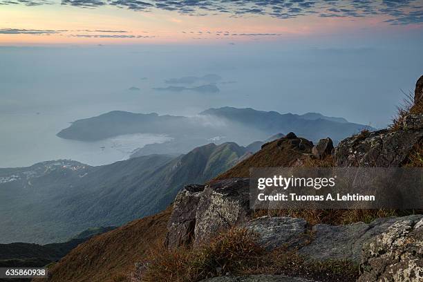 view of the coastline and hills on the lantau island from above, viewed from the   lantau peak (the 2nd highest peak in hong kong, china) at dawn. - lantau stock pictures, royalty-free photos & images