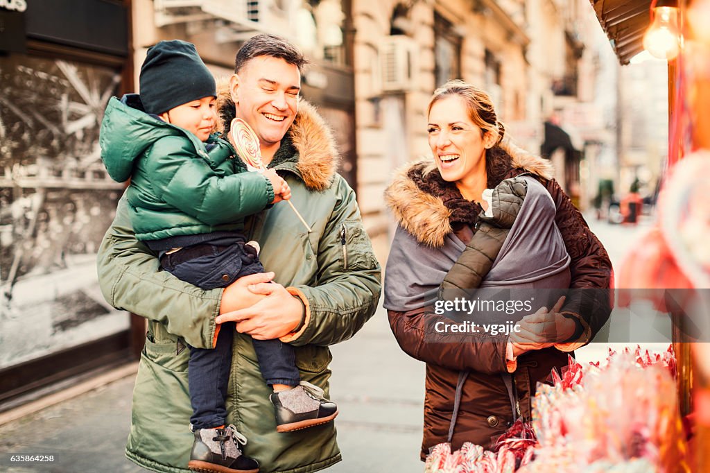 Mother And Father Buying Sweets To Their Son