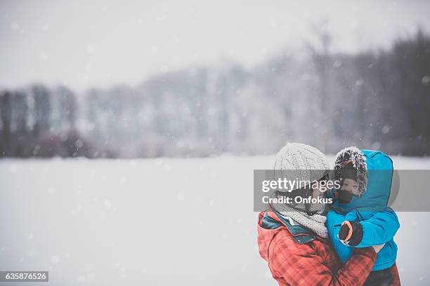 mother and son in winter forest snowstorm - winter baby stock pictures, royalty-free photos & images