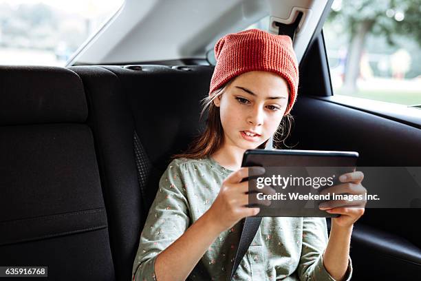 roadtrip für pre-teen mit tablet - girl in car with ipad stock-fotos und bilder