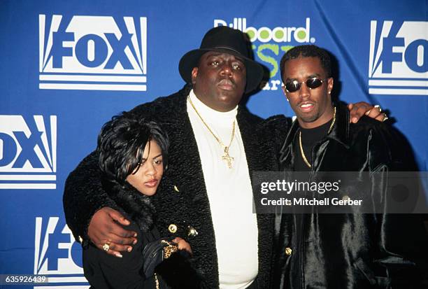 East Coast gangsta rapper Chris Wallace, known as The Notorious B.I.G., stands between songwriter Sean "Puffy" Combs, and rapper Little Kim at the...