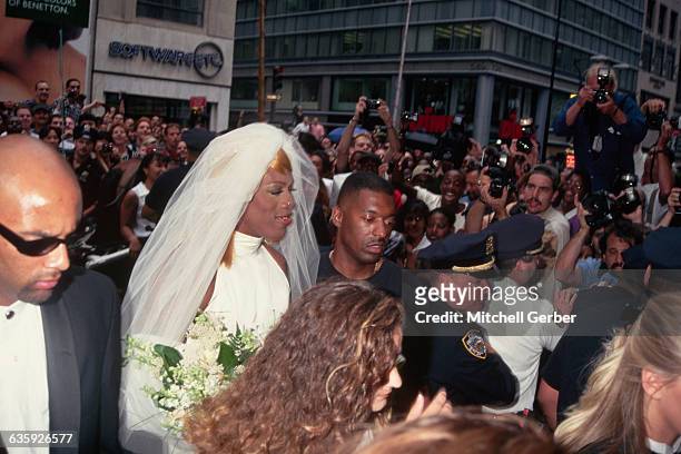 Basketball star and actor Dennis Rodman, dressed as a bride, arrives in Rockefeller Center with his beautiful young groomswomen.