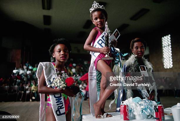 Little girl proudly displays her trophy beauty contest in Tokoza township. | Location: Tokoza, South Africa.