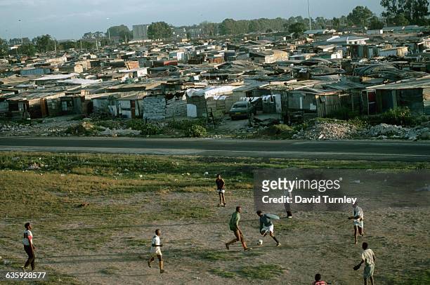 South African boys play soccer alongside Crossroads, one of the largest squatter settlements in South Africa, just outside Cape Town.