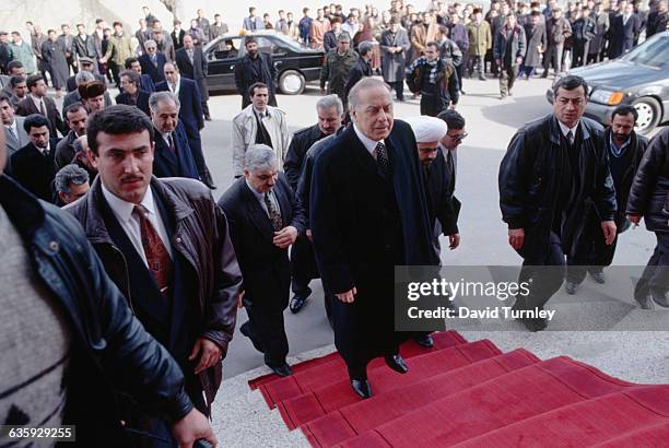 President Heydar and Azerbaijani officials walk up steps while a crowd of onlookers watch.